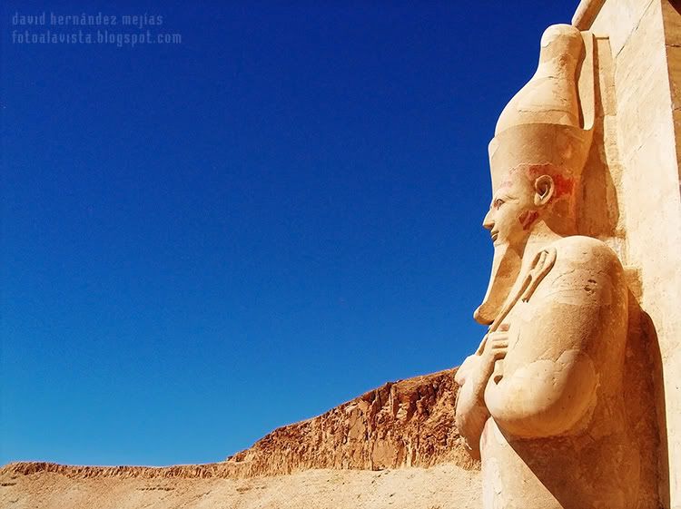 La mirada perdida del faraón Fotografía de un escultural y colosal faraón de piedra a la entrada de un mágnífico templo, que parece tener la mirada perdida hacia el desierto de pasadas civilizaciones. Egipto